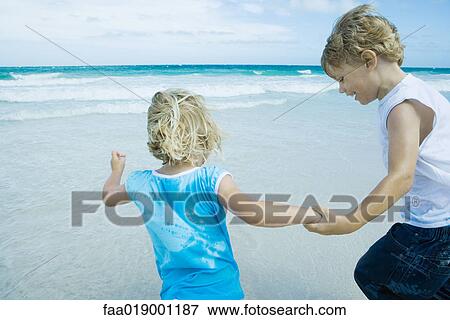 Children holding hands on beach View Large Photo Image Stock Photo - Children holding hands on beach. Fotosearch