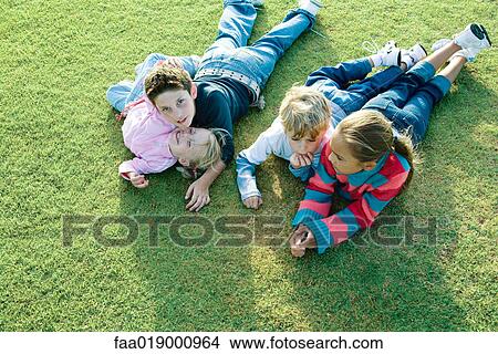 Children lying on grass together View Large Photo Image Picture - Children lying on grass together. Fotosearch