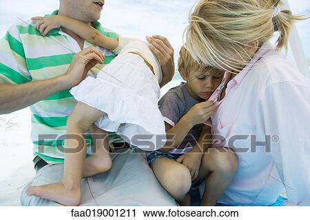 Children on parents' laps at beach, cropped view View Large Photo Image Stock Image - Children on parents' laps at beach, cropped view. Fotosearch