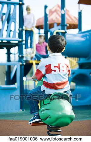 Stock Photograph - Children on playground equipment. Fotosearch