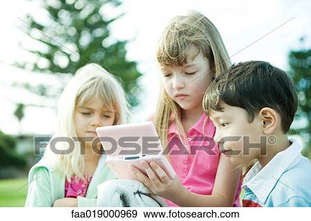 Stock Photo - Children on playground, playing video game. Fotosearch