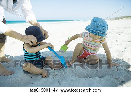 Stock Photo - Children playing in sand. Fotosearch