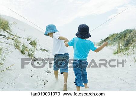 Children running through dunes, holding hands View Large Photo Image Stock Photo - Children running through dunes, holding hands. Fotosearch