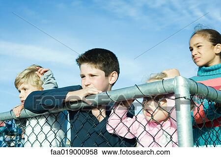 Stock Photo - Children standing behind fence. Fotosearch