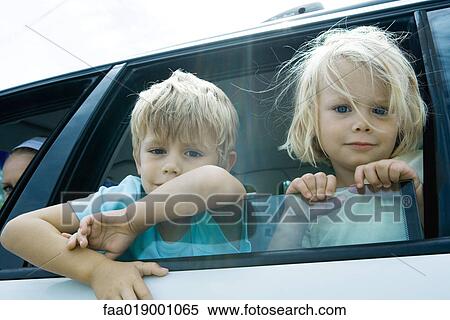 Stock Photography - Children sticking heads out of car window. Fotosearch