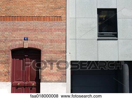 Stock Photo - Close-up of two building facades, one in red brick and the other in concrete. Fotosearch