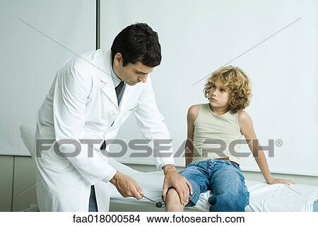 Doctor checking boy's reflexes View Large Photo Image Picture - Doctor checking boy's reflexes. Fotosearch