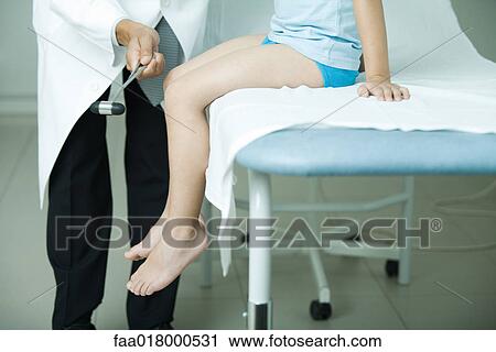 Doctor checking boy's reflexes with reflex hammer View Large Photo Image Stock Image - Doctor checking boy's reflexes with reflex hammer. Fotosearch