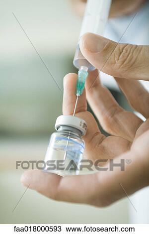 Doctor filling syringe from bottle View Large Photo Image Stock Image - Doctor filling syringe from bottle. Fotosearch