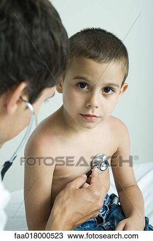 Doctor listening to boy's chest with stethoscope View Large Photo Image Stock Image - Doctor listening to boy's chest with stethoscope. Fotosearch