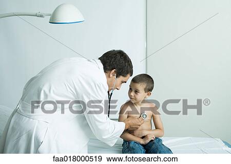 Doctor listening to boy's chest with stethoscope View Large Photo Image Stock Photo - Doctor listening to boy's chest with stethoscope. Fotosearch