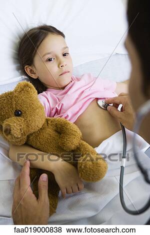 Stock Photo - Doctor listening to child's chest with stethoscope. Fotosearch