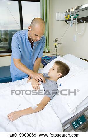 Stock Photography - Doctor listening to child's chest with stethoscope. Fotosearch