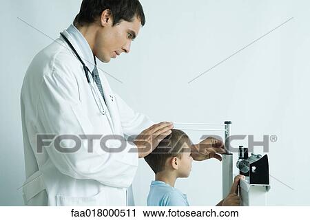 Stock Image - Doctor measuring boy during check-up. Fotosearch