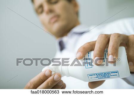 Doctor pouring antiseptic onto cotton ball View Large Photo Image Stock Image - Doctor pouring antiseptic onto cotton ball. Fotosearch