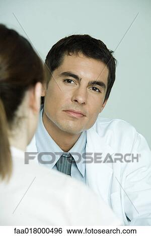Stock Photograph - Doctor sitting across from female patient. Fotosearch