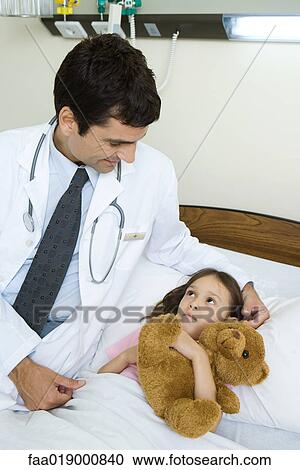 Doctor sitting next to sick child View Large Photo Image Stock Image - Doctor sitting next to sick child. Fotosearch