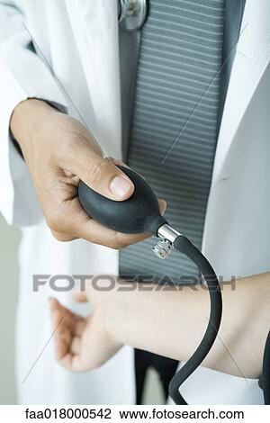 Doctor taking woman's blood pressure, close-up View Large Photo Image Stock Image - Doctor taking woman's blood pressure, close-up. Fotosearch