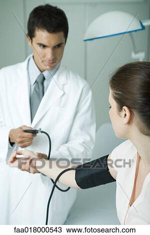 Doctor taking woman's blood pressure View Large Photo Image Stock Image - Doctor taking woman's blood pressure. Fotosearch
