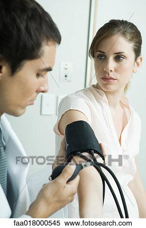 Stock Photography - Doctor taking woman's blood pressure. Fotosearch