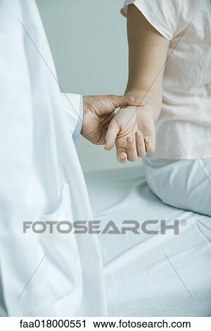 Doctor taking woman's pulse, close-up View Large Photo Image Stock Image - Doctor taking woman's pulse, close-up. Fotosearch