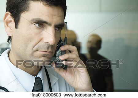 Doctor using cell phone, looking away View Large Photo Image Stock Image - Doctor using cell phone, looking away. Fotosearch