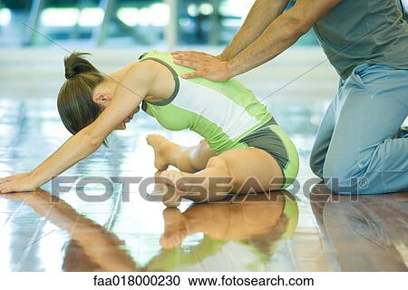 Exercise instructor helping woman stretch View Large Photo Image Stock Image - Exercise instructor helping woman stretch. Fotosearch