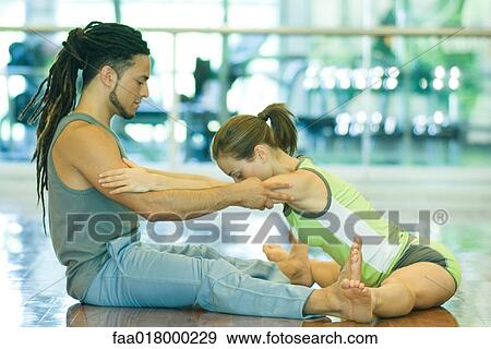 Exercise instructor helping woman stretch View Large Photo Image Stock Photo - Exercise instructor helping woman stretch. Fotosearch