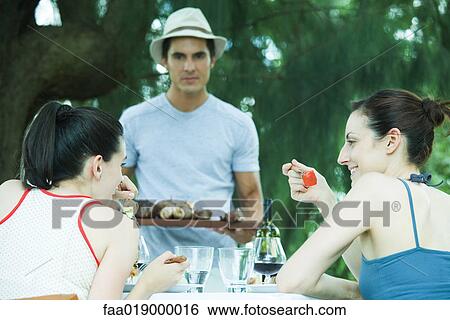 Family eating outdoors View Large Photo Image Stock Photograph - Family eating outdoors. Fotosearch