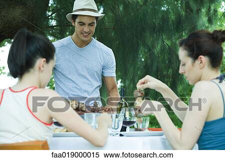 Stock Photography - Family eating outdoors. Fotosearch