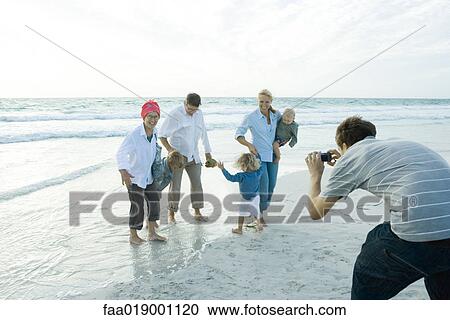 Family on beach, man taking photo View Large Photo Image Stock Image - Family on beach, man taking photo. Fotosearch