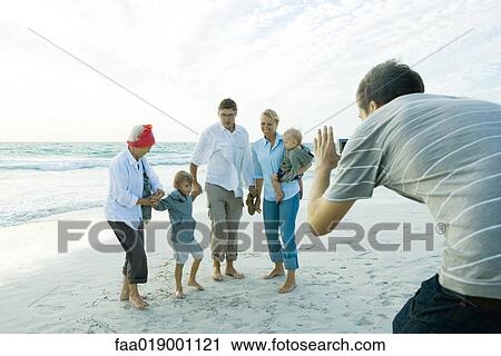 Family on beach, man taking photo View Large Photo Image Stock Image - Family on beach, man taking photo. Fotosearch