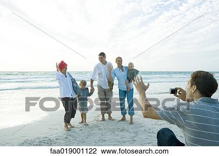Family on beach, man taking photo View Large Photo Image Stock Image - Family on beach, man taking photo. Fotosearch