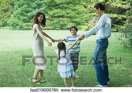 Stock Photography - Family outdoors playing ring-around-the-rosy. Fotosearch