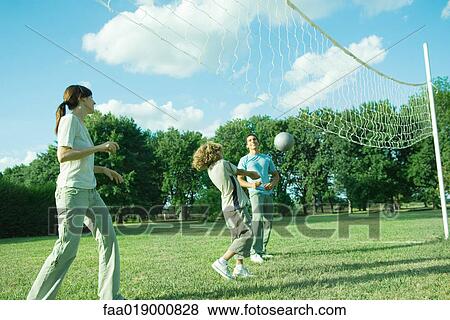 Stock Photo - Family outdoors playing volleyball. Fotosearch