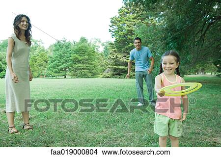 Picture - Family playing with plastic disc . Fotosearch