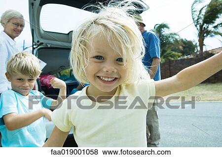 Family unloading trunk of car, focus on little girl in foreground View Large Photo Image Stock Photo - Family unloading trunk of car, focus on little girl in foreground. Fotosearch