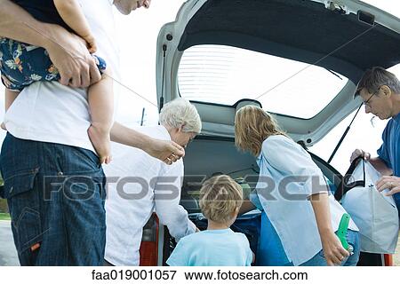Stock Photo - Family unloading trunk of car. Fotosearch