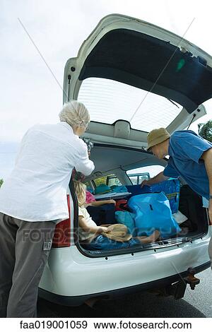 Family unloading trunk of car View Large Photo Image Stock Photo - Family unloading trunk of car. Fotosearch