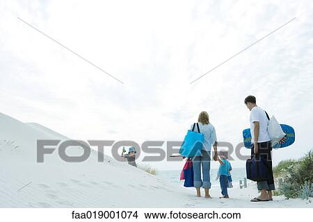 Picture - Family walking through dunes to beach. Fotosearch