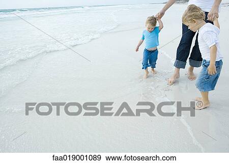 Father and children walking in surf View Large Photo Image Stock Photo - Father and children walking in surf. Fotosearch