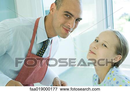 Father and daughter sharing spaghetti noodle, smiling at camera View Large Photo Image Stock Photo - Father and daughter sharing spaghetti noodle, smiling at camera. Fotosearch