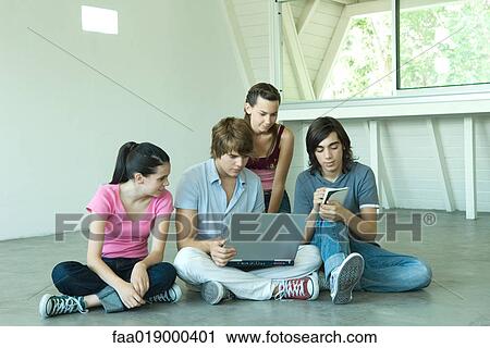 Four teen friends sitting on floor together, using laptop View Large Photo Image Stock Image - Four teen friends sitting on floor together, using laptop. Fotosearch