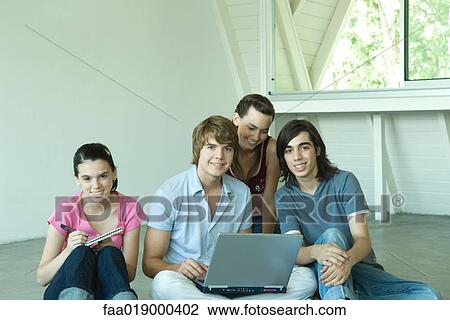Four teen friends sitting on floor together, using laptop View Large Photo Image Stock Image - Four teen friends sitting on floor together, using laptop. Fotosearch