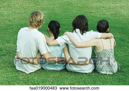 Four young friends sitting on grass, side by side, with arms around each other, rear view View Large Photo Image Stock Image - Four young friends sitting on grass, side by side, with arms around each other, rear view. Fotosearch