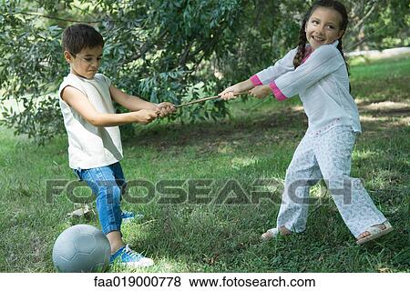 Girl and boy playing tug-of-war View Large Photo Image Stock Photo - Girl and boy playing tug-of-war. Fotosearch