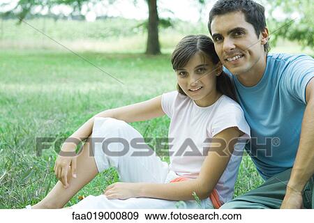 Girl and father sitting outdoors, portrait View Large Photo Image Stock Photo - Girl and father sitting outdoors, portrait. Fotosearch