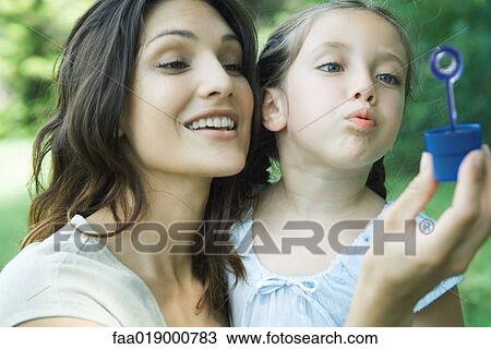 Girl and mother blowing bubbles together View Large Photo Image Stock Image - Girl and mother blowing bubbles together. Fotosearch