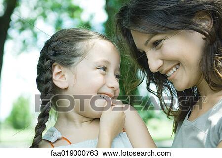 Girl and mother looking at each other, close-up View Large Photo Image Stock Image - Girl and mother looking at each other, close-up. Fotosearch