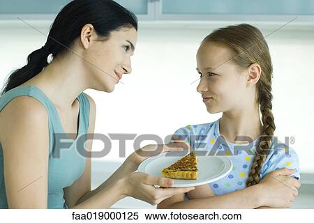 Girl crossing arms, looking at woman holding piece of quiche View Large Photo Image Stock Photography - Girl crossing arms, looking at woman holding piece of quiche. Fotosearch